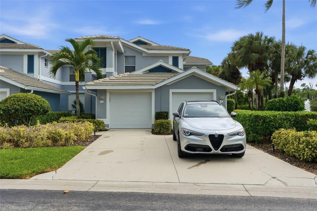 A two-story gray townhouse with a two-car garage and a silver SUV parked outside — 710 TARPON COVE DRIVE UNIT 203, NAPLES, FL