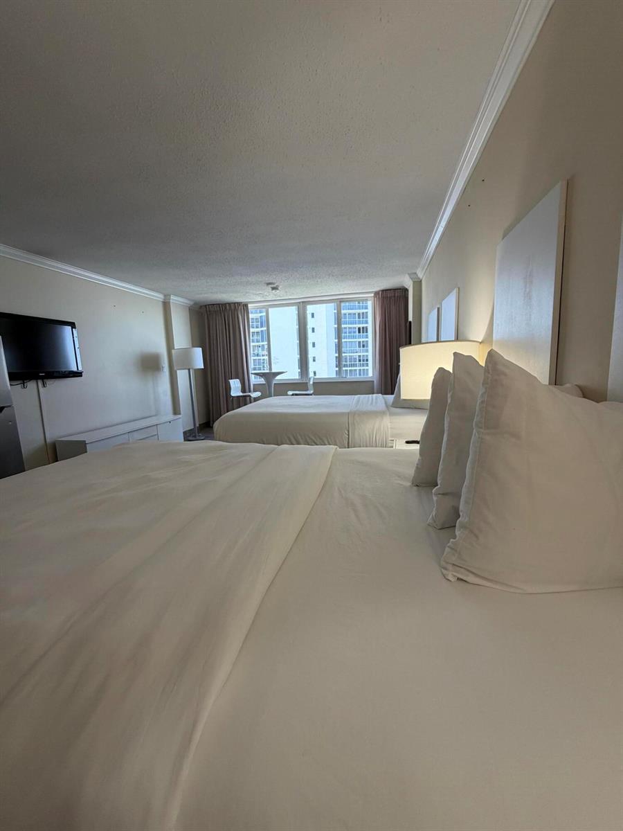 A hotel room features two queen beds, a television, and a window with city views — 19201 Collins Avenue, Sunny Isles Beach FL 33160, SUNNY ISLES BEACH, FL