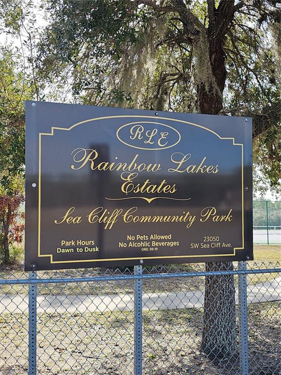 A dark brown sign for Rainbow Lakes Estates Sea Cliff Community Park stands behind a fence — TBD SE 136TH TERRACE, DUNNELLON, FL
