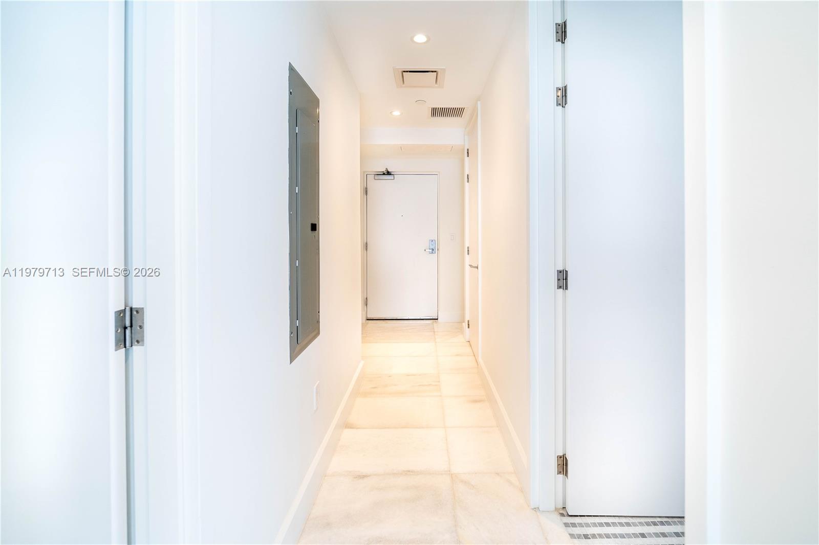 A bright hallway features white walls, tile flooring, and a central door at the end — 700 NE 26TH TER # 3006, Miami FL 33137, MIAMI, FL