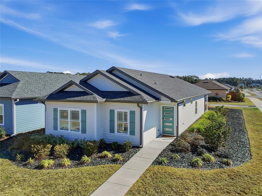 A single-story house with light siding, teal shutters, and a teal front door — 9639 SW 66TH LANE, GAINESVILLE, FL