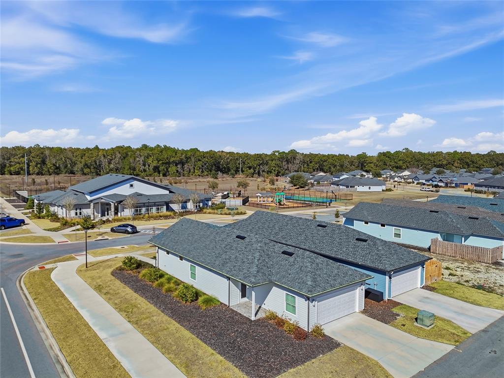 An aerial view shows a suburban neighborhood with houses, a community center, and a playground — 9639 SW 66TH LANE, GAINESVILLE, FL