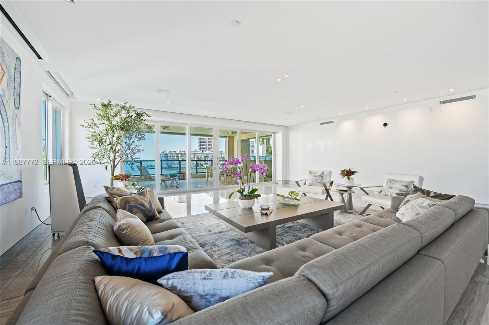 A spacious living room features a large gray sectional sofa, a coffee table, and floor-to-ceiling windows — 3535 Hiawatha Ave # 502, Miami FL 33133, MIAMI, FL