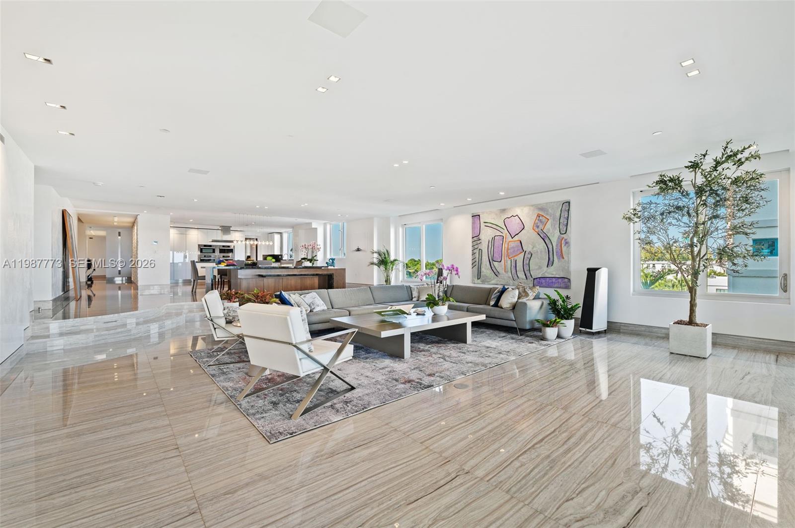 A spacious living room features marble floors, a large sectional sofa, and a potted tree — 3535 Hiawatha Ave # 502, Miami FL 33133, MIAMI, FL