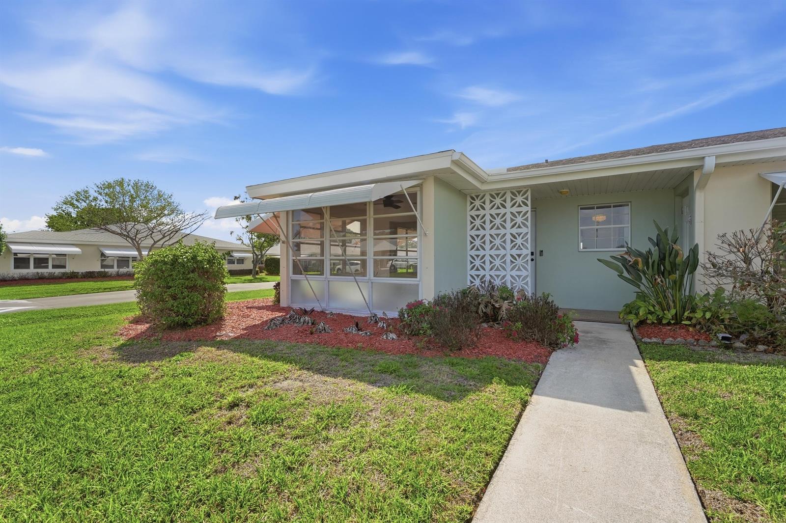 A single-story house with a screened-in porch, decorative breeze block wall, and concrete walkway — 203 Manatee Lane # A, Fort Pierce FL 34982, FORT PIERCE, FL