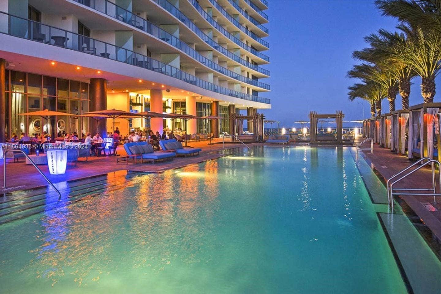 A large swimming pool sits beside a modern hotel building with outdoor lounge seating — 4111 S Ocean Dr # 2101, Hollywood FL 33019, HOLLYWOOD, FL