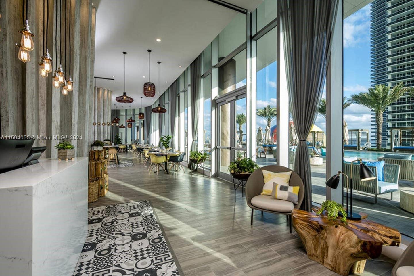 A modern lobby features patterned tile flooring, floor-to-ceiling windows, and views of an outdoor pool — 4111 S Ocean Dr # 2101, Hollywood FL 33019, HOLLYWOOD, FL