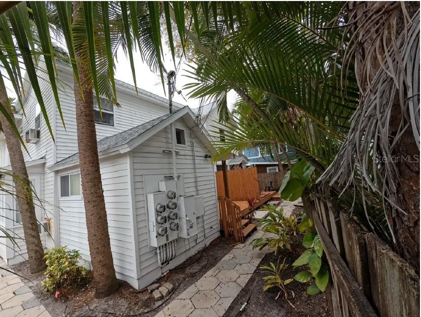 Exterior view of a white house with multiple electrical meters and a stone walkway — 255 6TH AVENUE N, ST PETERSBURG, FL