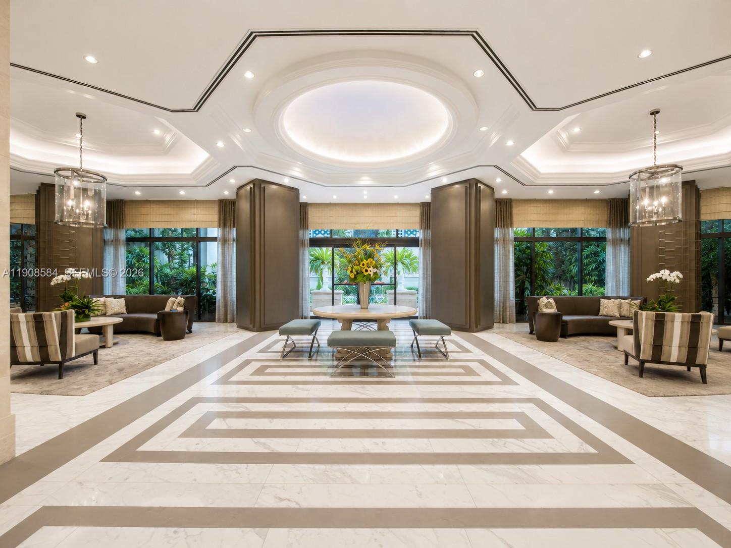 A spacious, symmetrical lobby features marble floors, a central circular ceiling, and two seating areas — 2000 Island Blvd # 1710, Aventura FL 33160, AVENTURA, FL