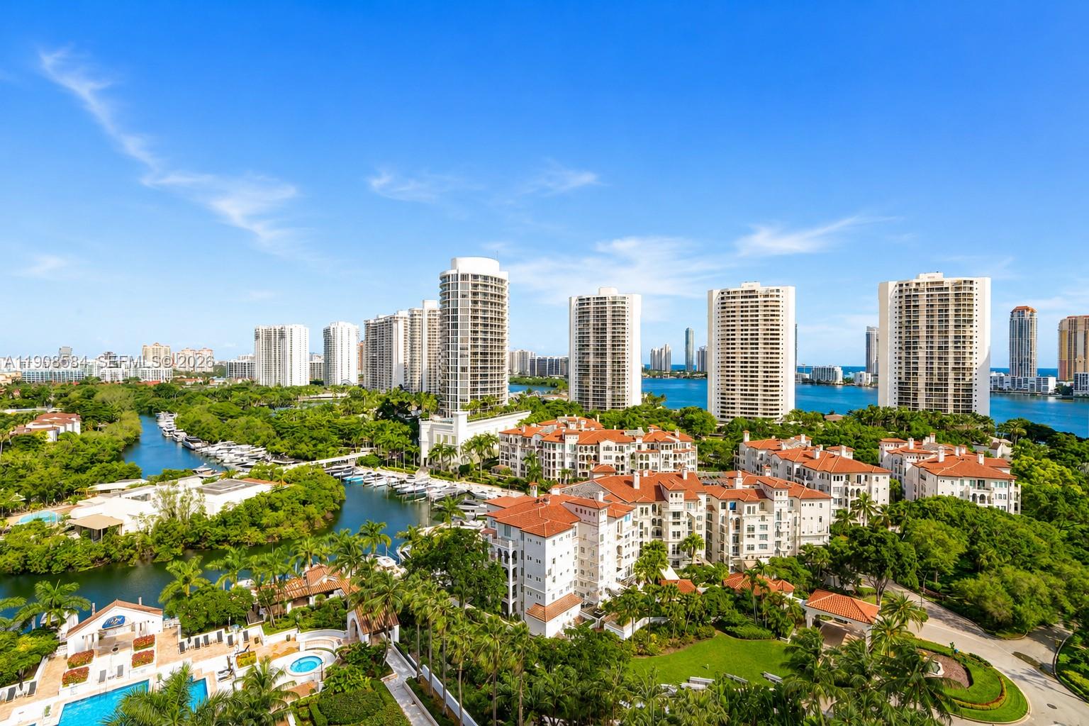 An aerial view shows residential high-rise buildings, a marina, and low-rise apartments with red roofs — 2000 Island Blvd # 1710, Aventura FL 33160, AVENTURA, FL