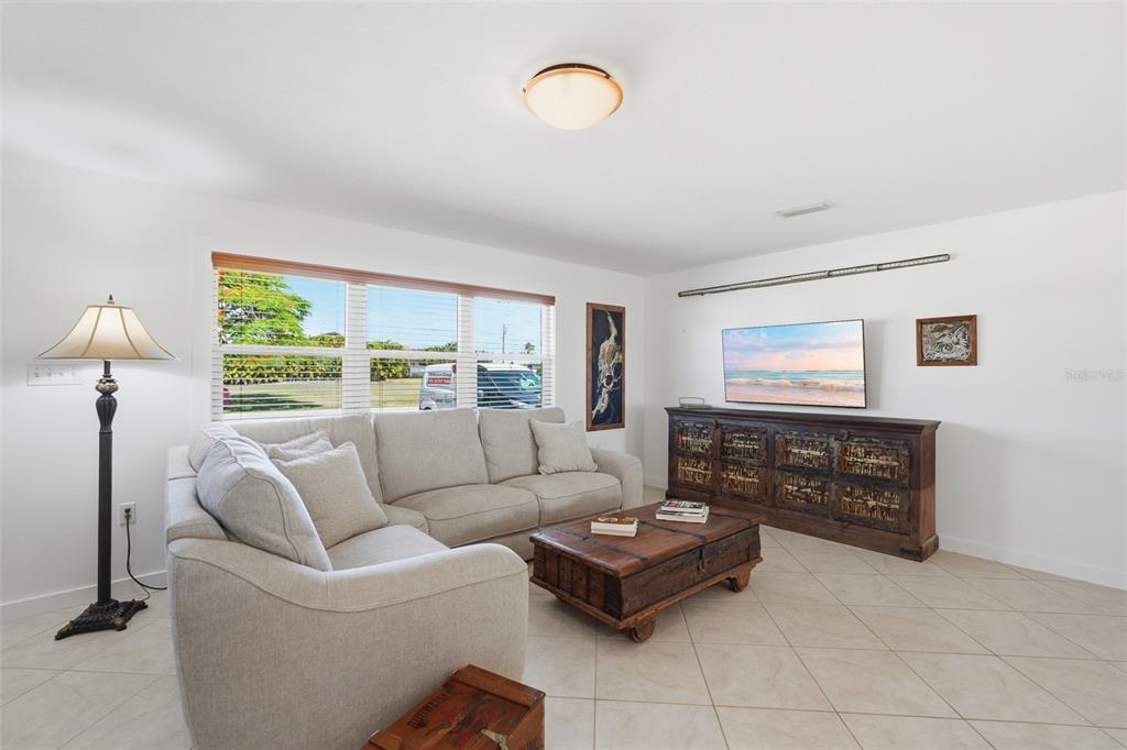 A living room features a beige sectional sofa, a wooden coffee table, and a television console — 4310 PALM DRIVE, PUNTA GORDA, FL