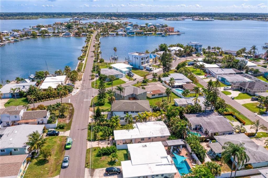 An aerial view shows a residential neighborhood situated on a narrow peninsula surrounded by water — 307 161ST AVENUE, REDINGTON BEACH, FL
