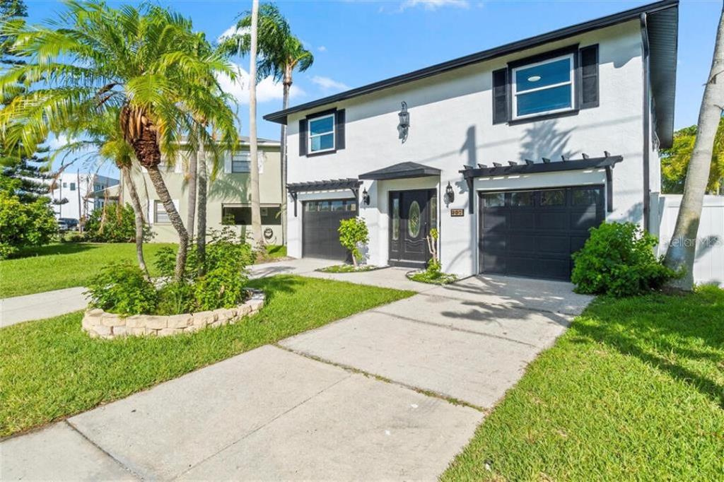 A two-story white house with black trim, two garage doors, and a front lawn — 307 161ST AVENUE, REDINGTON BEACH, FL