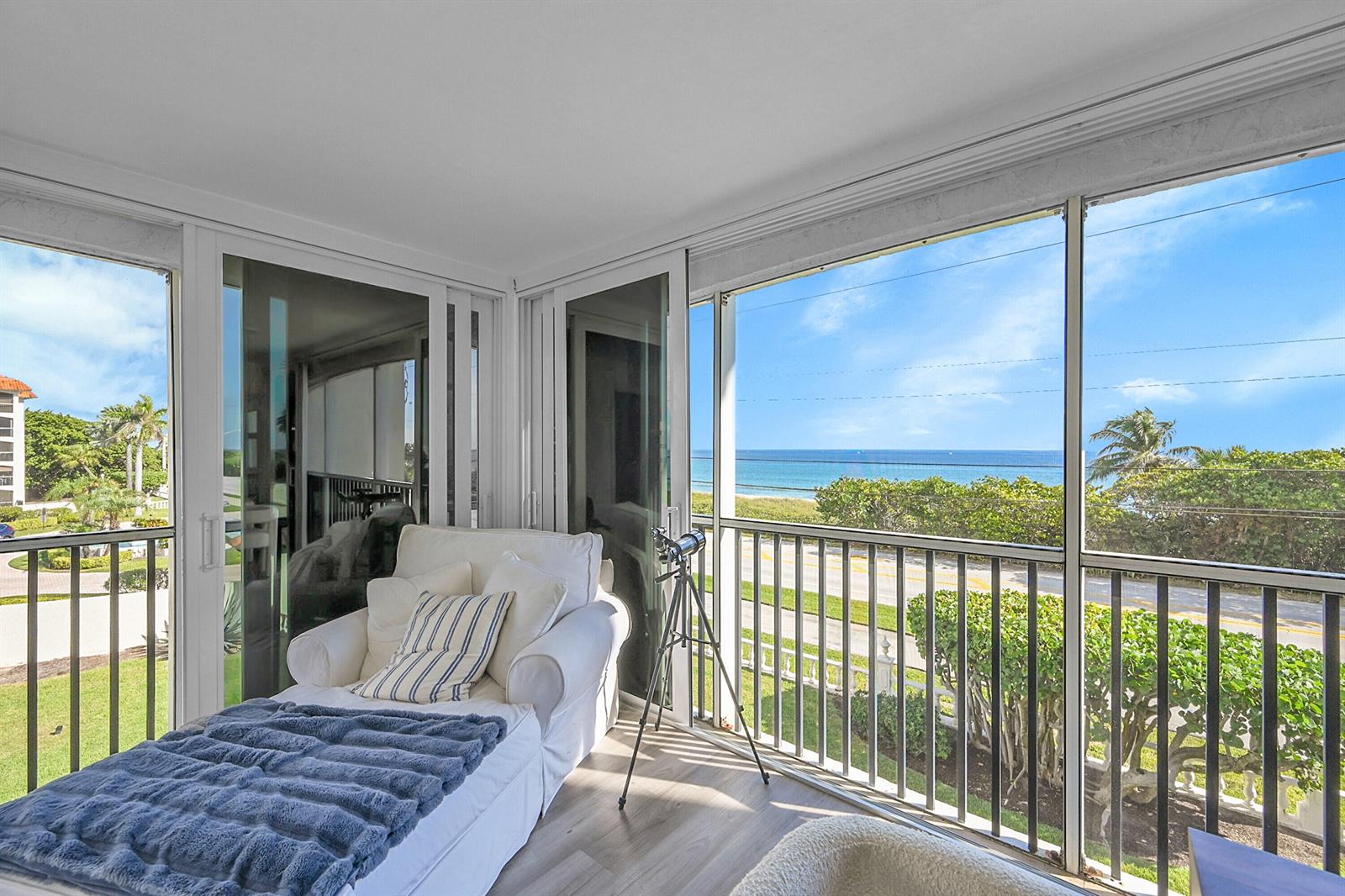 A sunroom features a white chaise lounge, a telescope, and floor-to-ceiling windows overlooking the ocean — 2871 N Ocean Boulevard # D302, Boca Raton FL 33431, BOCA RATON, FL