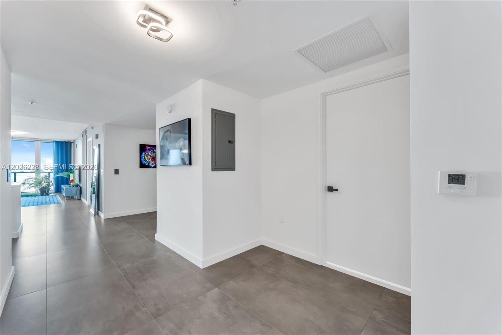 A hallway with gray tile flooring, white walls, a closed door, and a circuit breaker panel — 300 Sunny Isles Blvd # 905, Sunny Isles Beach FL 33160, SUNNY ISLES BEACH, FL