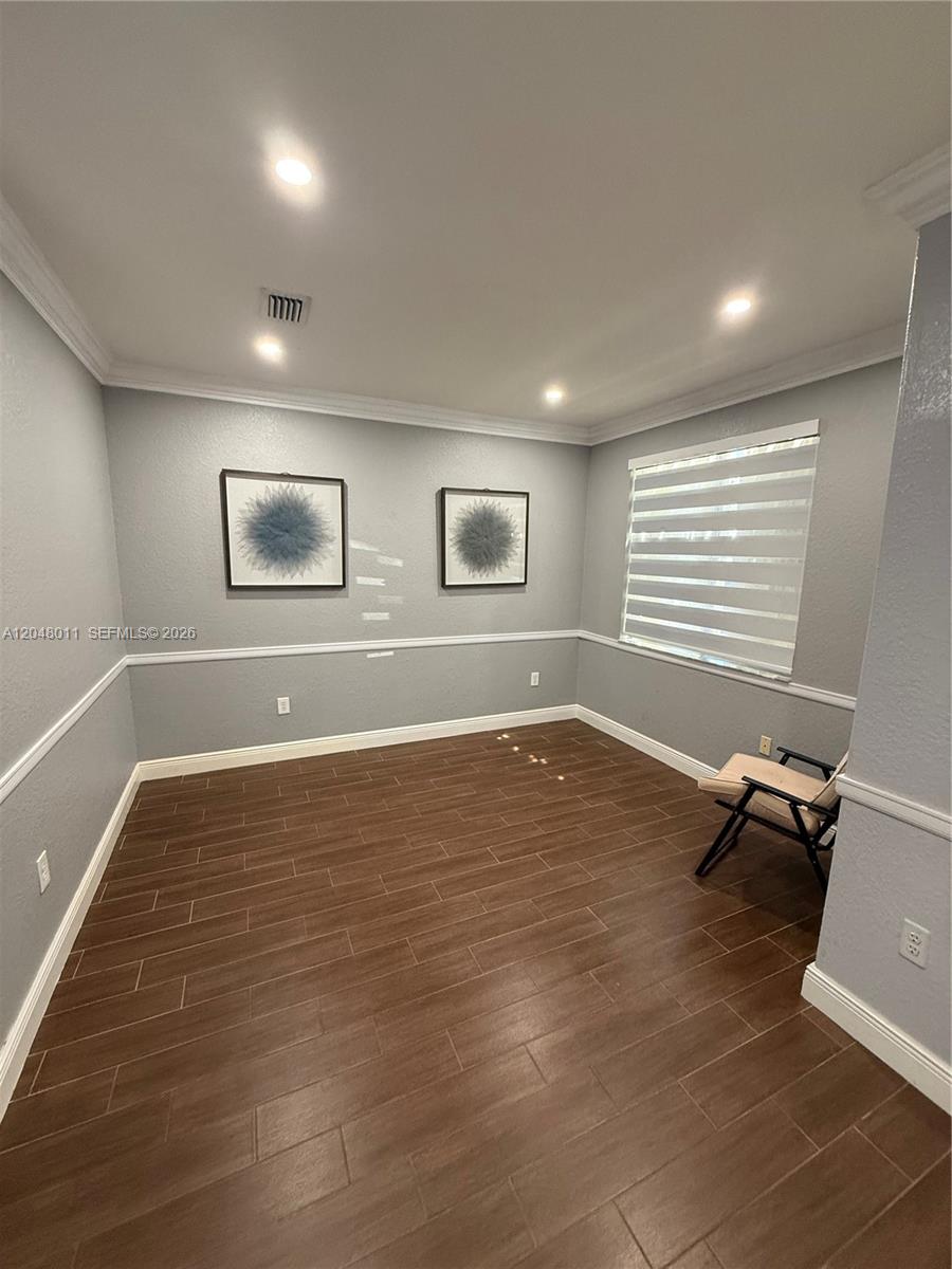 This room features gray walls, a chair rail, dark wood-look tile flooring, and two framed prints — 7353 NW 174th Ter # 107, Hialeah FL 33015, HIALEAH, FL