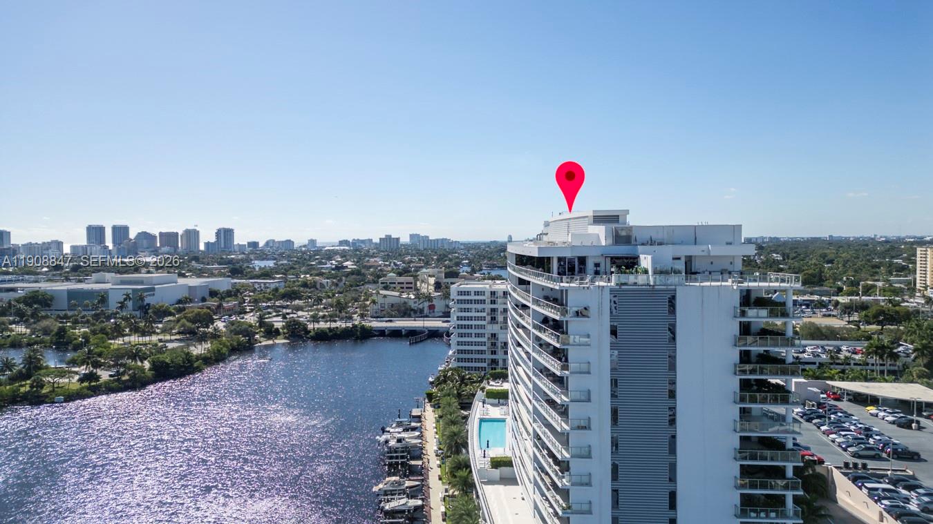 An aerial view shows a high-rise building next to a waterway with boats docked nearby — 1180 N Federal Hwy # 1602, Fort Lauderdale FL 33304, FORT LAUDERDALE, FL