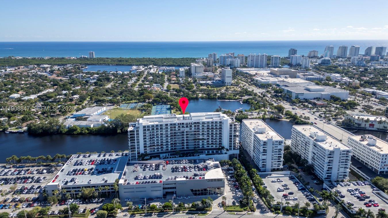 An aerial view shows a large apartment complex with a parking garage near a lake — 1180 N Federal Hwy # 1602, Fort Lauderdale FL 33304, FORT LAUDERDALE, FL