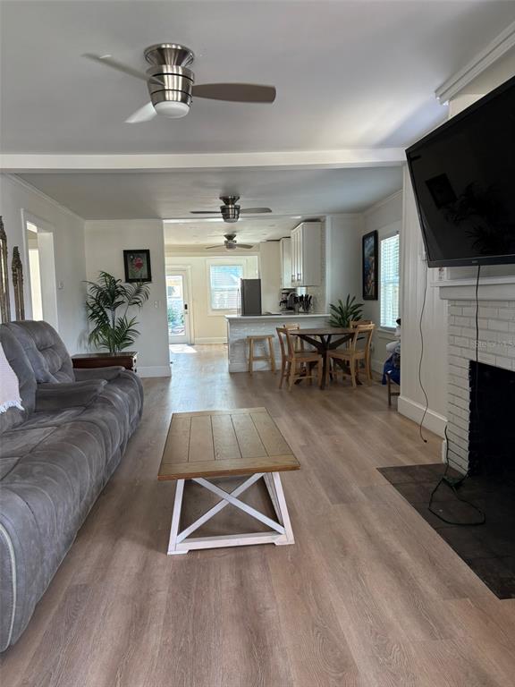 A living room with a gray sofa, wood coffee table, and an open kitchen beyond — 2570 LOMA LINDA STREET, SARASOTA, FL