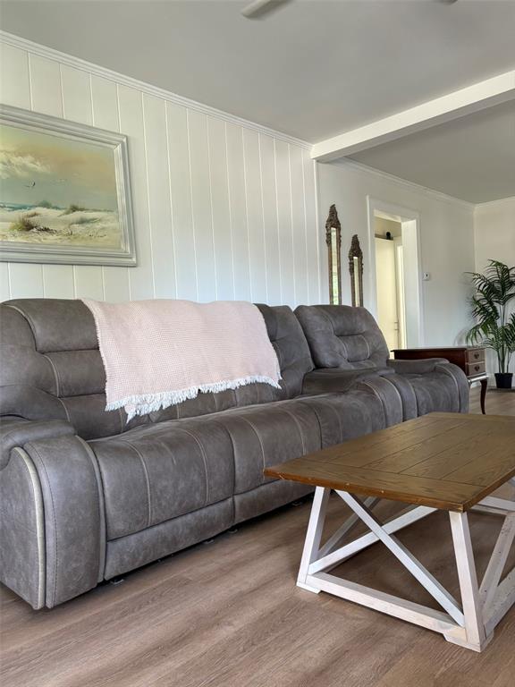 A living room features a grey reclining sofa, a wooden coffee table, and white paneling — 2570 LOMA LINDA STREET, SARASOTA, FL