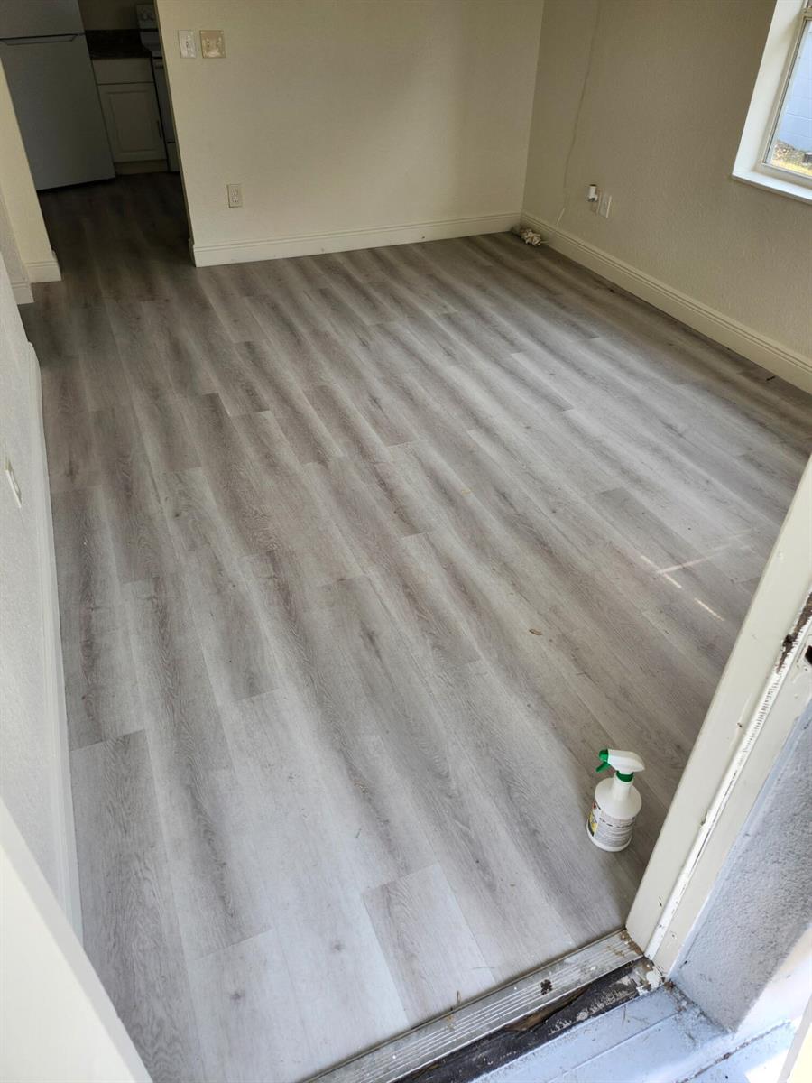 An interior view of a room featuring light-colored wood-look laminate flooring and white walls — 1401 G Terrace, Fort Pierce FL 34950, FORT PIERCE, FL