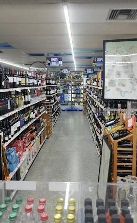 A view down a retail aisle lined with shelves stocked with various wine bottles — 503 ALT 19 HIGHWAY UNIT 503, PALM HARBOR, FL