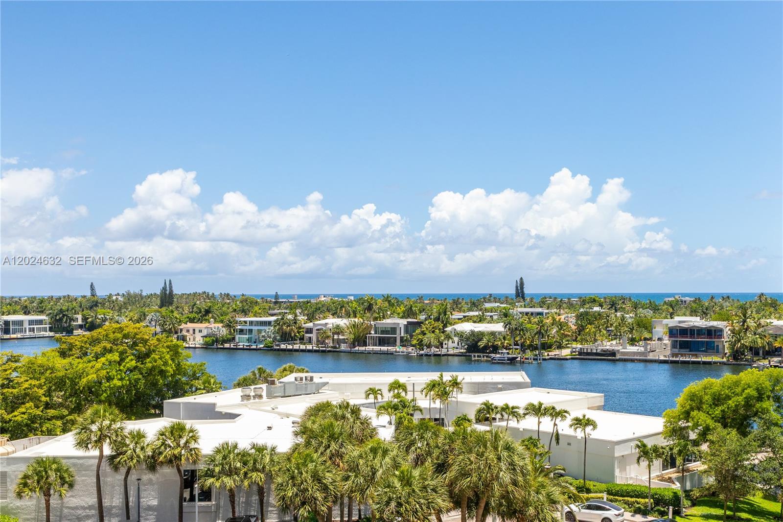 An elevated view shows a waterway lined with houses and palm trees under a blue sky — 20281 E Country Club Dr # 510, Aventura FL 33180, AVENTURA, FL