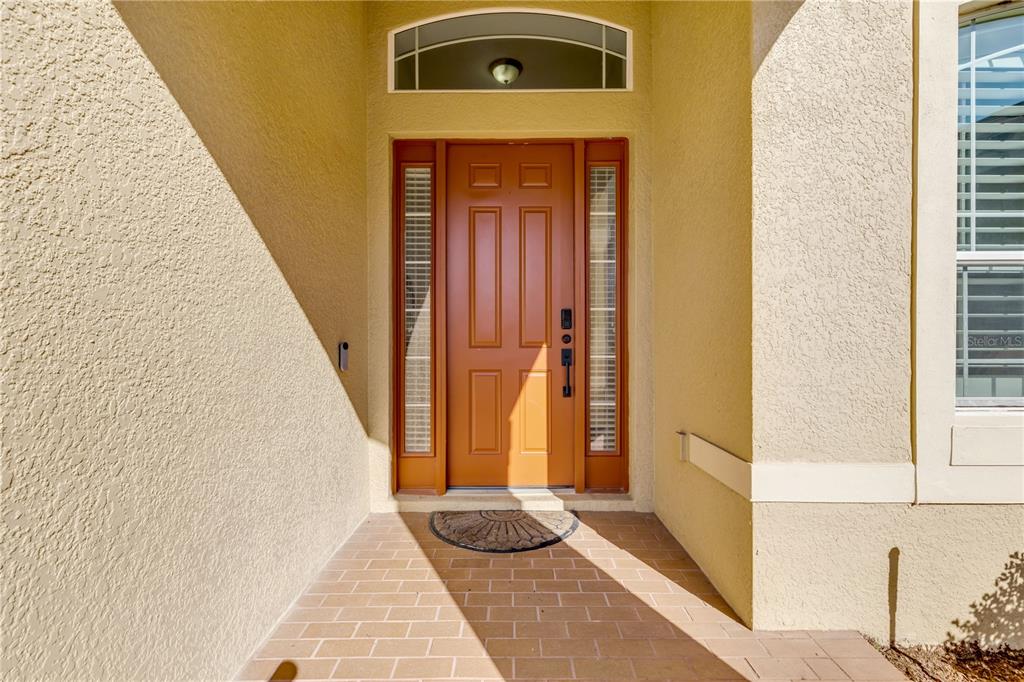 A front entryway features a tan door with sidelights, a transom window, and tiled flooring — 3021 ISOLA BELLA BOULEVARD, MOUNT DORA, FL
