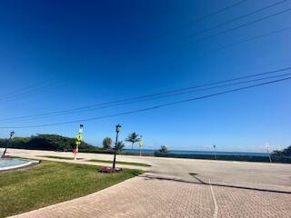 A paved driveway leads toward a coastal road with a view of the ocean — 2871 N Ocean Boulevard # V457, Boca Raton FL 33431, BOCA RATON, FL