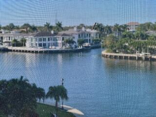 A view of a canal and waterfront homes seen through a window screen — 2871 N Ocean Boulevard # V457, Boca Raton FL 33431, BOCA RATON, FL