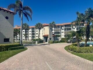 A paved driveway leads to a multi-story apartment building surrounded by palm trees — 2871 N Ocean Boulevard # V457, Boca Raton FL 33431, BOCA RATON, FL