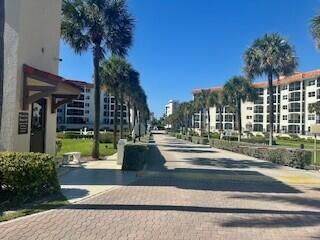 A paved driveway leads between two large apartment buildings lined with palm trees — 2871 N Ocean Boulevard # V457, Boca Raton FL 33431, BOCA RATON, FL