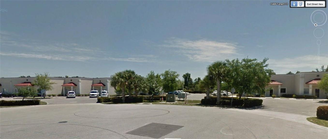 A view of a commercial office complex with a paved parking lot and palm trees — 1685 Target Court, FL 33905, FL