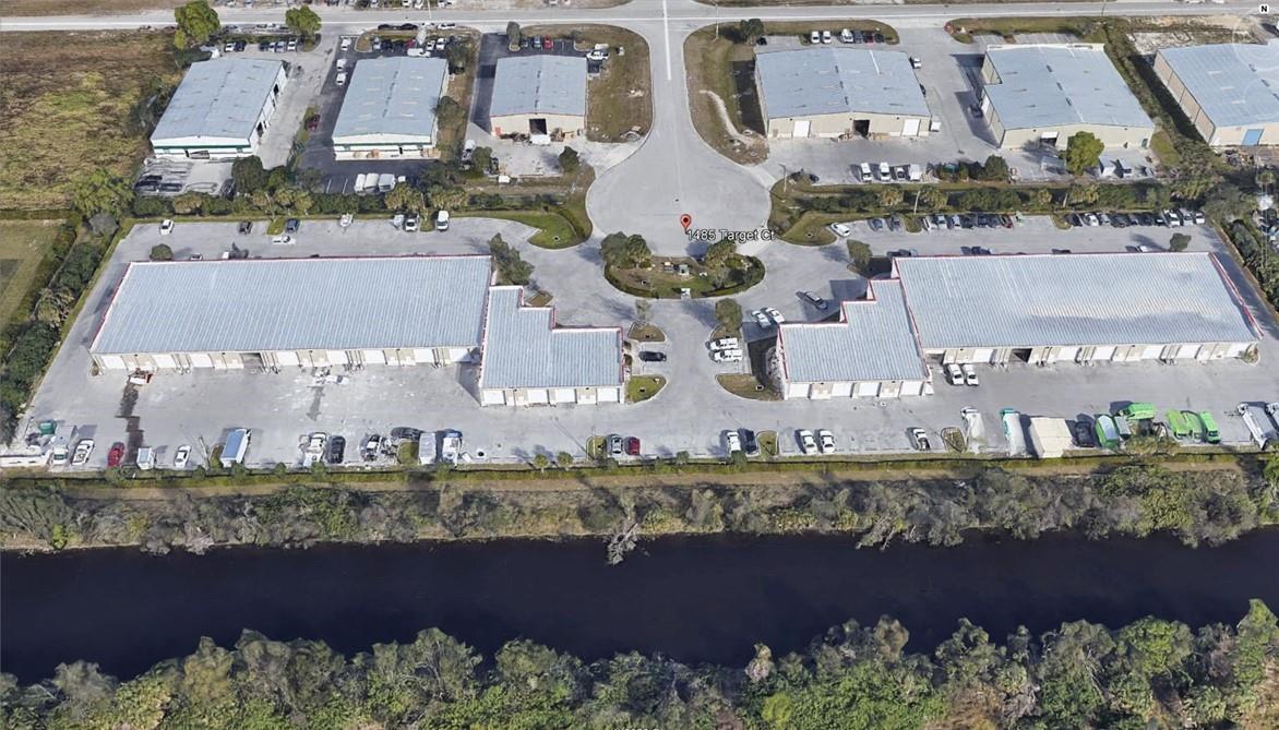 An aerial view shows two large commercial warehouse buildings with parking lots and a nearby canal — 1685 Target Court, FL 33905, FL