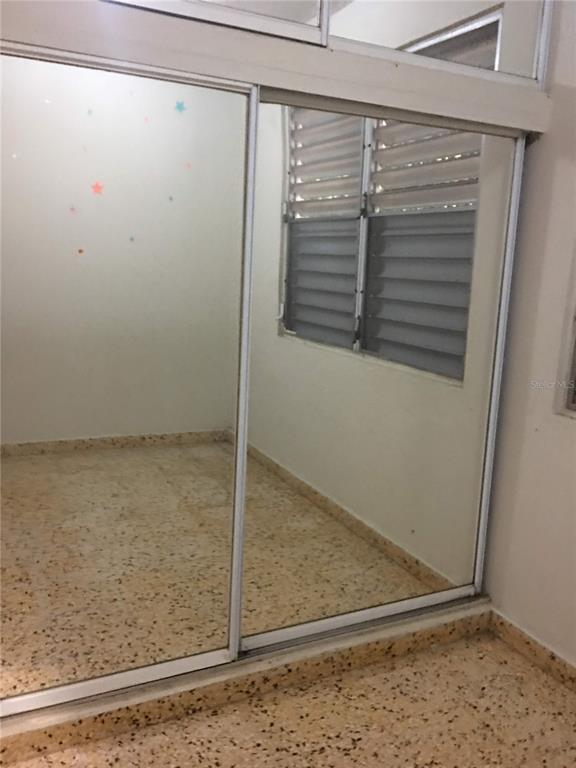 A room features mirrored sliding closet doors, a window with louvers, and speckled terrazzo flooring — 352 BARRIO QUEMADO, MAYAGUEZ, PR