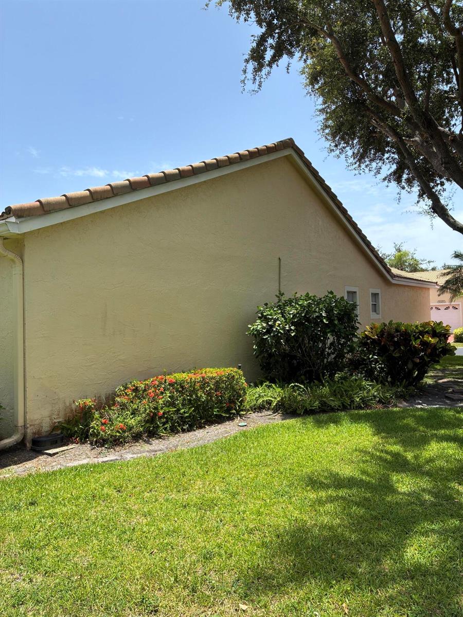 A side view of a yellow stucco house with a tile roof and landscaping — 17223 Boca Club Boulevard # 6, Boca Raton FL 33487, BOCA RATON, FL