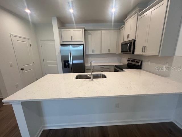 A kitchen features white cabinets, stainless steel appliances, and a large quartz-topped island — 11525 STRAITS WAY, ORLANDO, FL