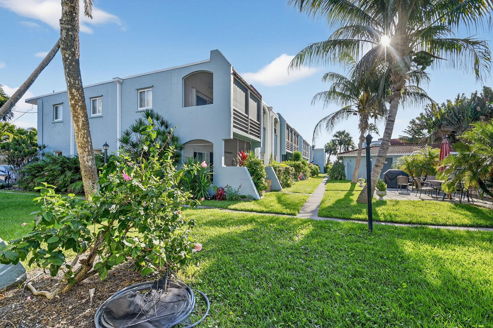 A light blue multi-story apartment building sits behind a grassy lawn with palm trees — 1432 S Lakeside Drive # 4, FL 33460, FL