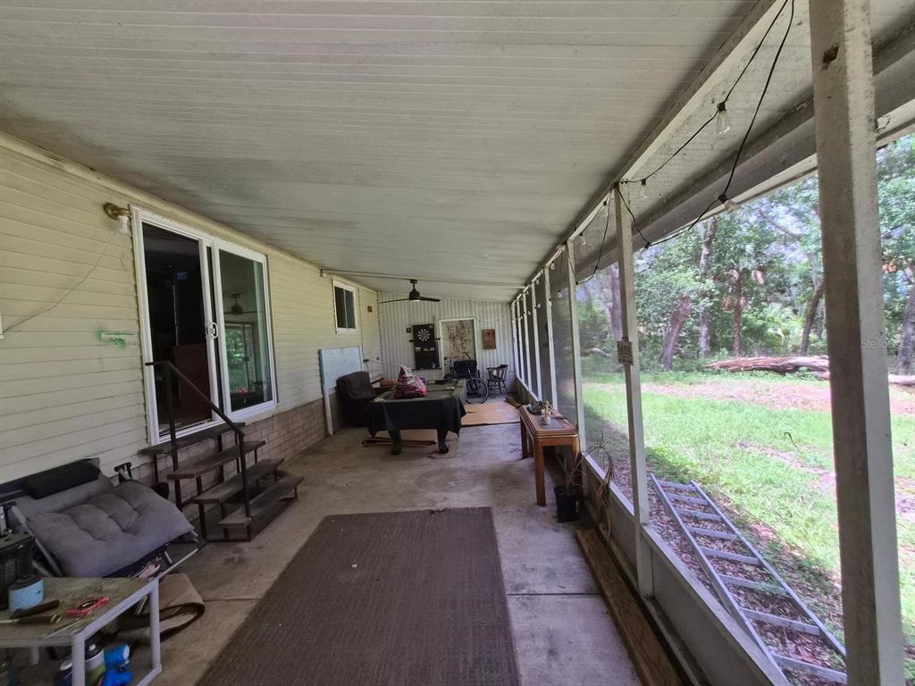 A covered screened-in porch with a concrete floor, a pool table, and exterior siding — 14179 NE 53RD COURT ROAD, CITRA, FL