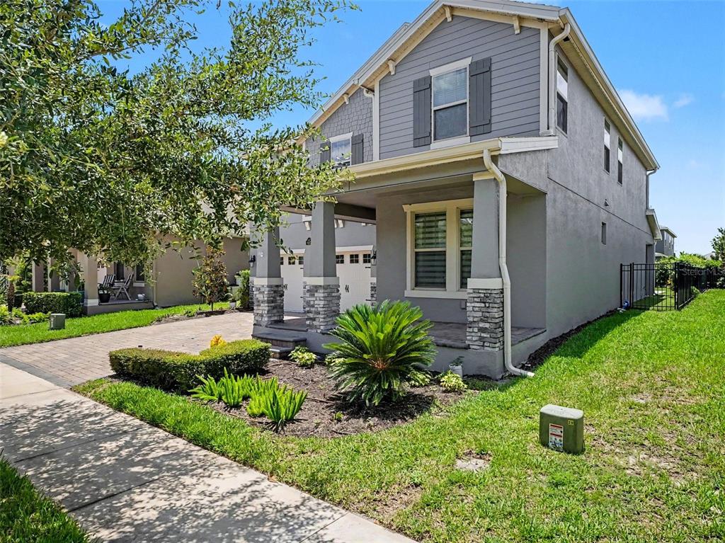 A two-story gray house with a stone-accented front porch and a paved driveway — 9572 WATERWAY PASSAGE DRIVE, WINTER GARDEN, FL