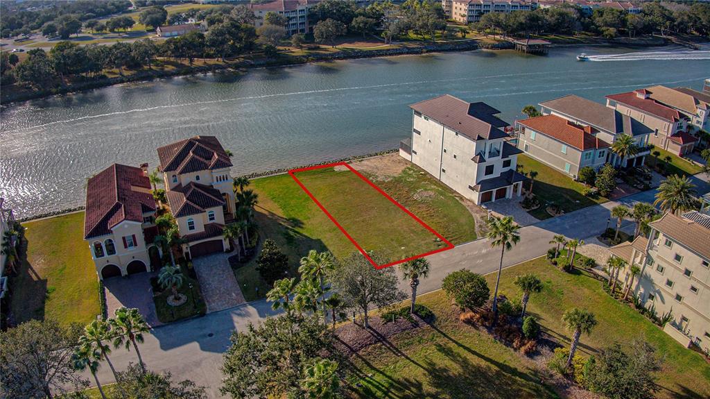 An aerial view shows a vacant waterfront lot outlined in red between two large houses — 276 YACHT HARBOR DRIVE, PALM COAST, FL