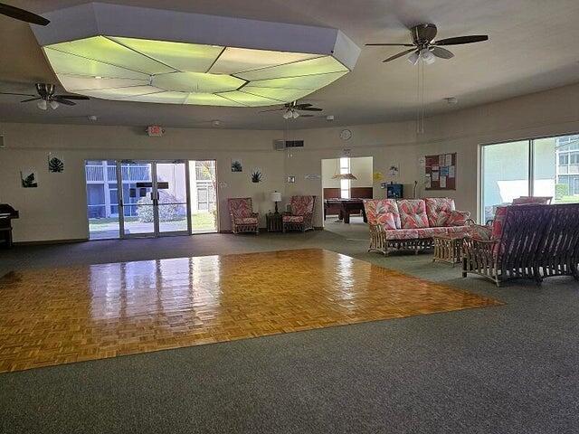 A large community room features a parquet dance floor, ceiling fans, and floral-patterned seating — 300 Village Green Circle S # 209, Palm Springs FL 33461, PALM SPRINGS, FL