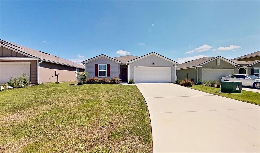 A single-story house with light gray siding, a two-car garage, and a concrete driveway — 5471 HOLLOW BIRCH DRIVE, JACKSONVILLE, FL