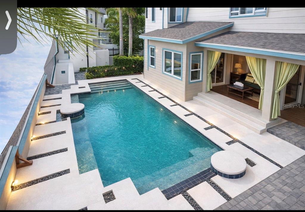An elevated view of a rectangular swimming pool with a patio and covered seating area — 9406 DUGARD COURT, ORLANDO, FL