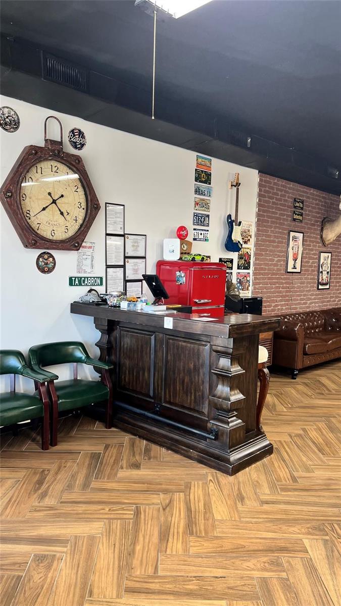 A reception area features a dark wood counter, a red mini-fridge, and wall-mounted decor — 20th Street, Boca Raton FL 33431, BOCA RATON, FL