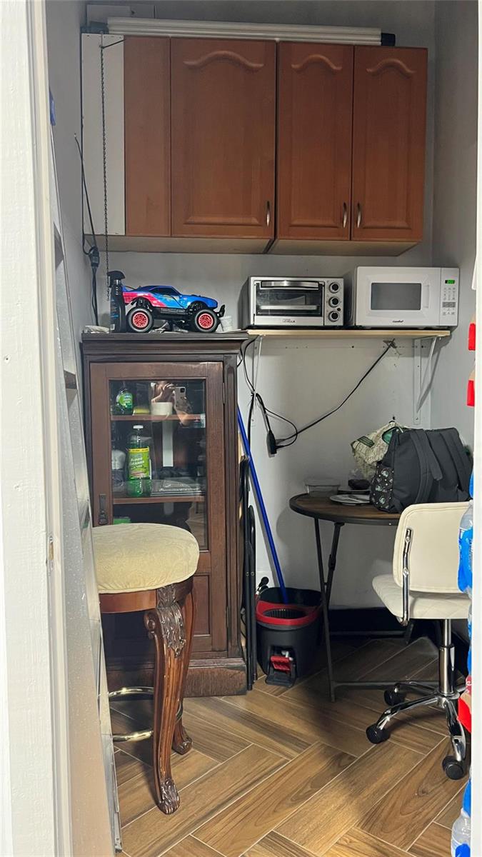 A small utility room features wood cabinets, a microwave, a toaster oven, and a desk — 20th Street, Boca Raton FL 33431, BOCA RATON, FL