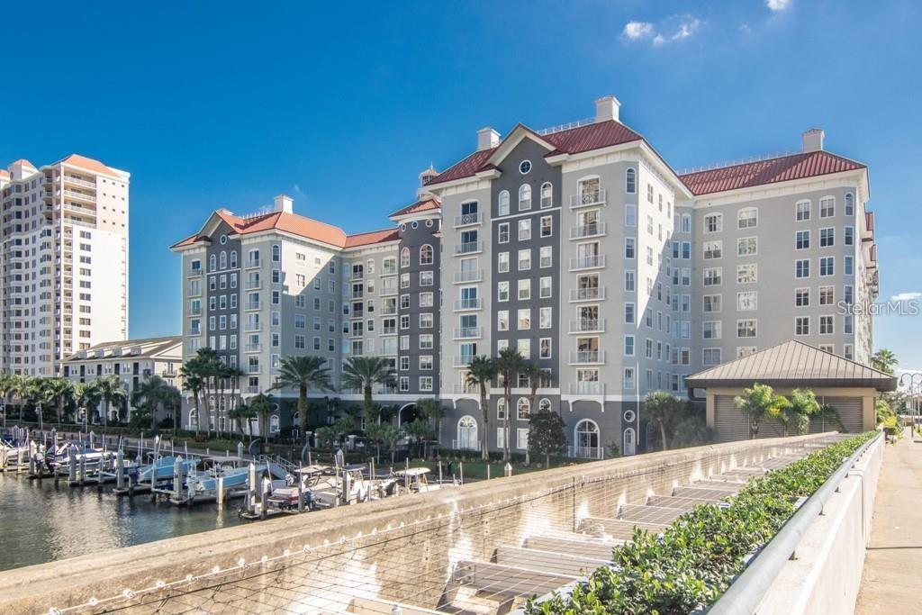 A multi-story apartment building with a red roof stands next to a boat marina — 700 S HARBOUR ISLAND BOULEVARD UNIT 523, TAMPA, FL