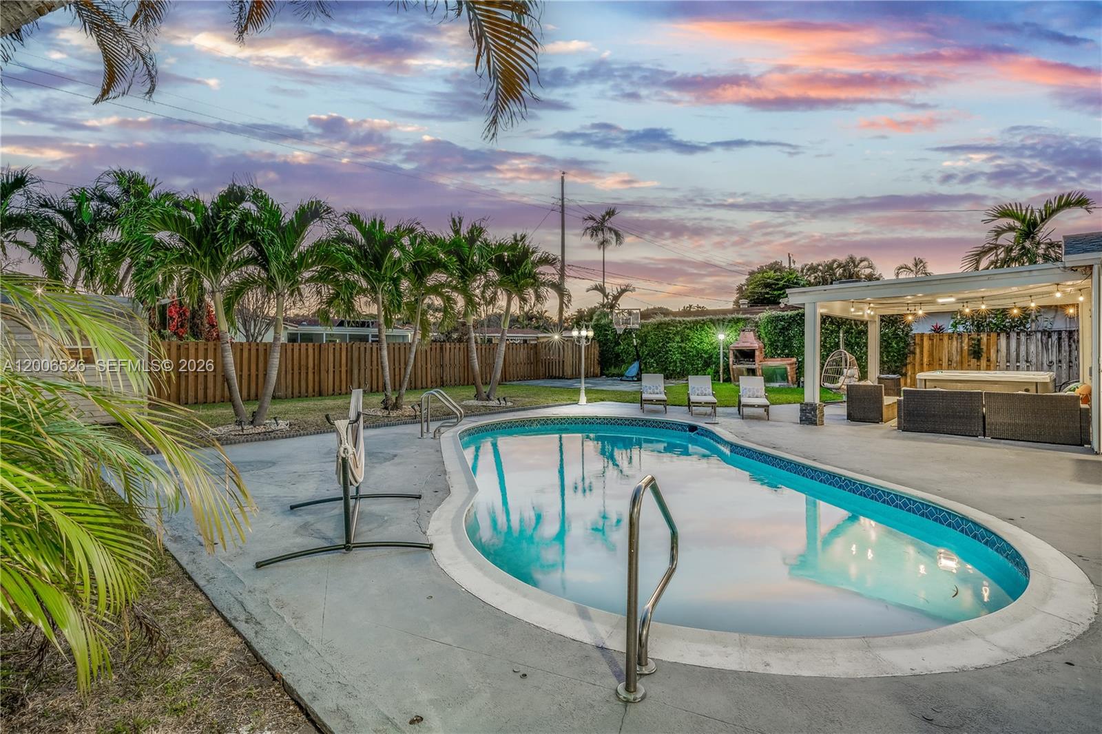 A backyard features a kidney-shaped swimming pool, a covered patio, and several palm trees — 4212 Van Buren St # 0, Hollywood FL 33021, HOLLYWOOD, FL