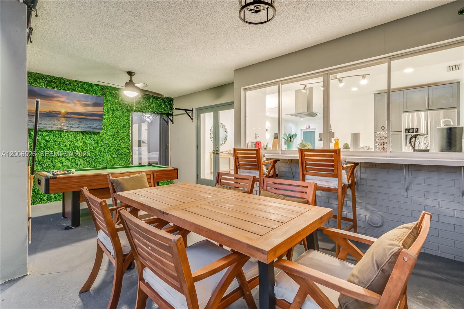 A covered patio features a pool table, dining set, bar seating, and a green wall — 4212 Van Buren St # 0, Hollywood FL 33021, HOLLYWOOD, FL