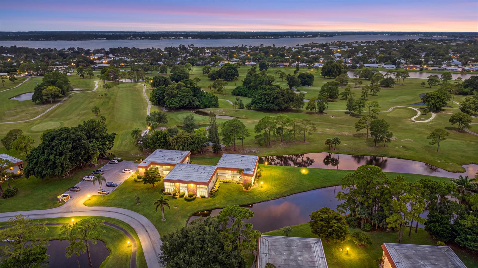An aerial view shows a multi-unit building situated next to a golf course and pond — 1225 NW 21st Street # 1708, Stuart FL 34994, STUART, FL